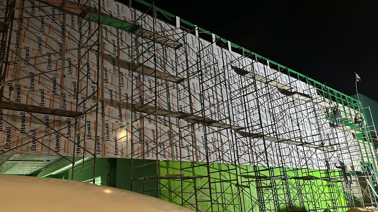 Instalación nocturna de panel de aluminio compuesto en fachada Localiza