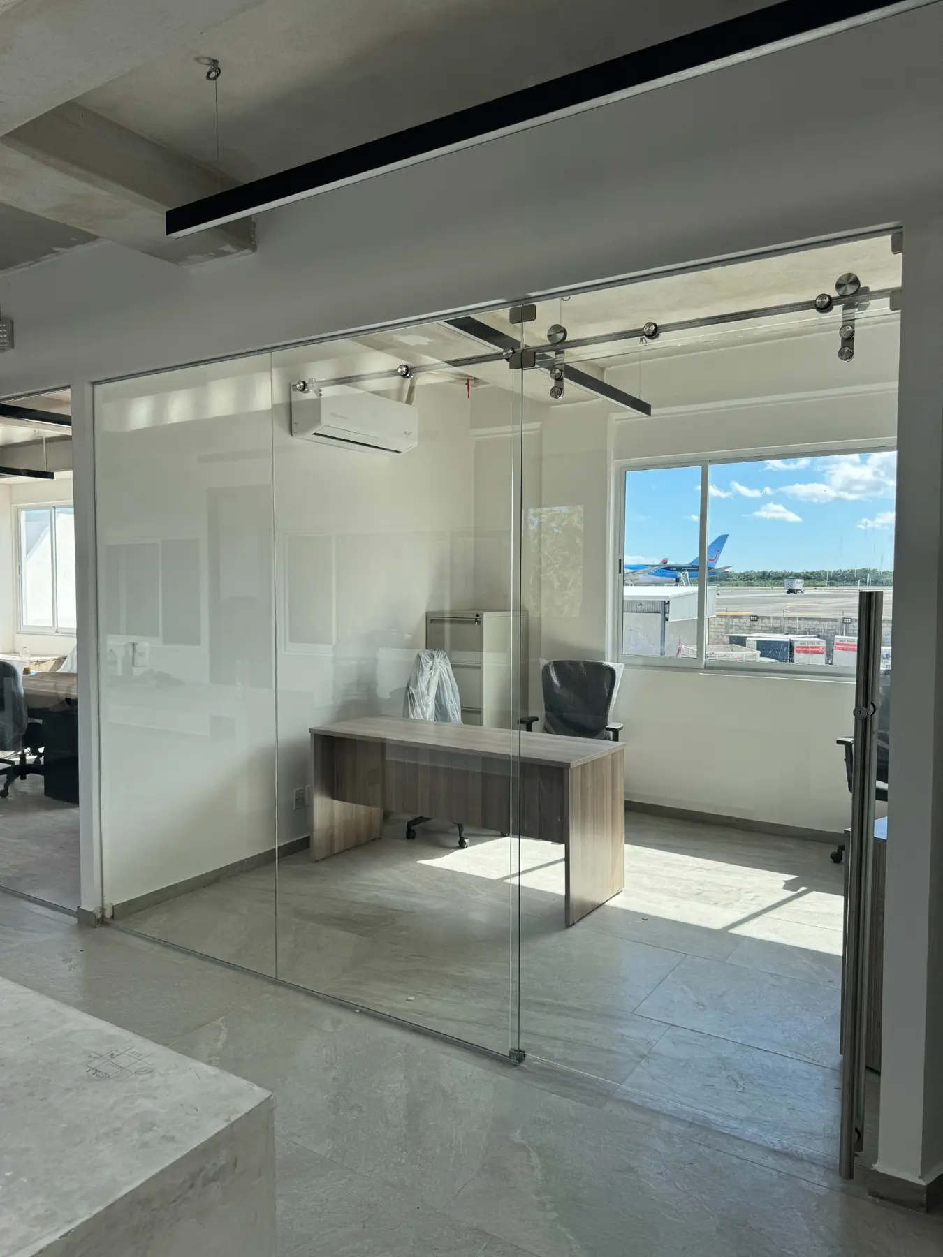 Oficinas Swissport con divisiones y puertas corredizas de vidrio