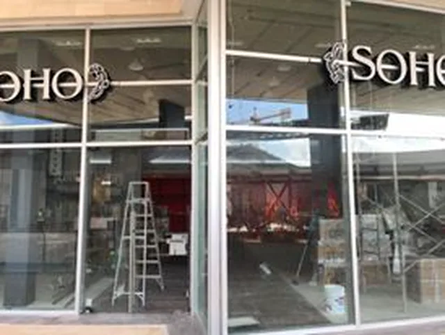 Fachada de vidrio y puertas automáticas de tienda Soho en Marina Town Center